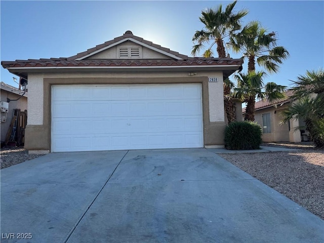 ranch-style house with a tiled roof, stucco siding, and driveway