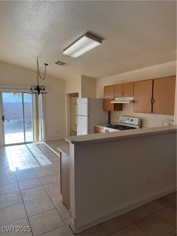 kitchen featuring visible vents, white appliances, a textured ceiling, under cabinet range hood, and light tile patterned floors