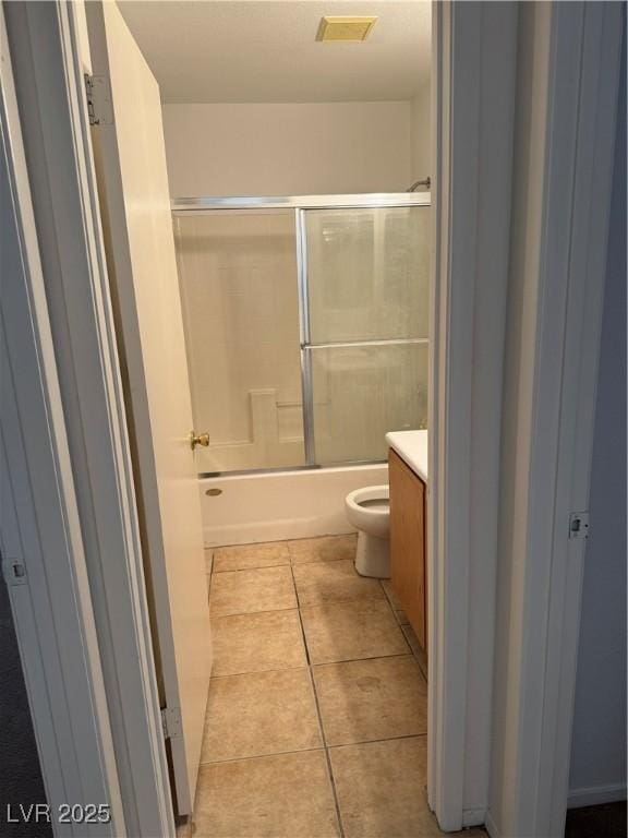 full bathroom featuring vanity, tile patterned floors, toilet, and shower / bath combination with glass door