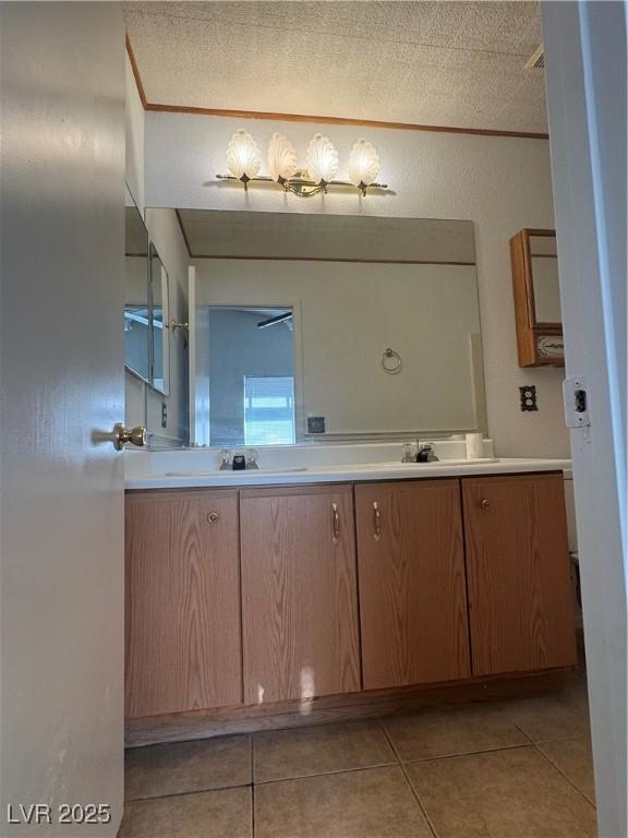 bathroom featuring double vanity, tile patterned floors, and a sink