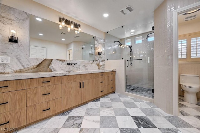 full bathroom featuring vanity, toilet, a wealth of natural light, and a stall shower