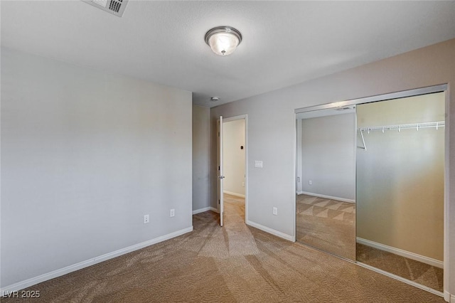 unfurnished bedroom featuring carpet flooring, baseboards, visible vents, and a closet