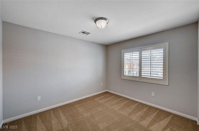 spare room with baseboards, carpet flooring, and visible vents