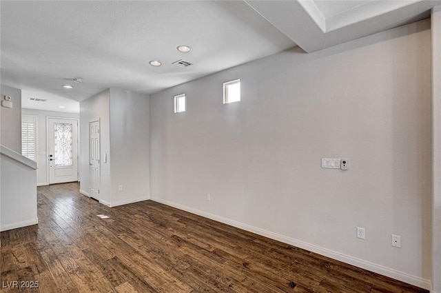 spare room with baseboards, dark wood-type flooring, recessed lighting, and visible vents
