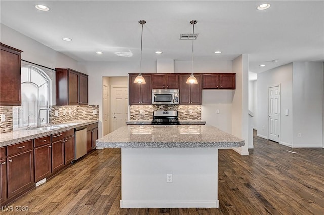 kitchen featuring visible vents, tasteful backsplash, a sink, dark wood finished floors, and appliances with stainless steel finishes