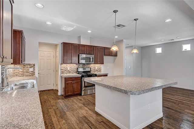 kitchen with a sink, stainless steel appliances, dark wood-style floors, and visible vents