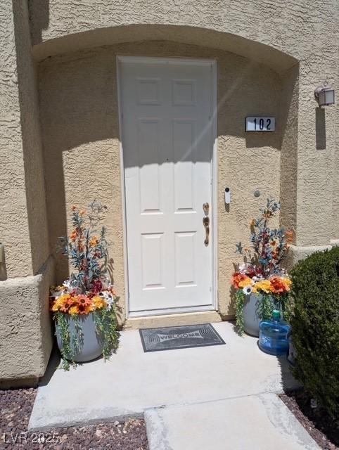 view of exterior entry featuring stucco siding