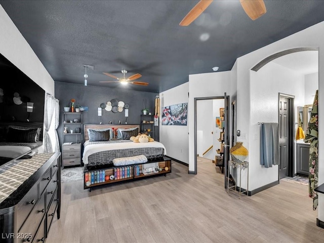 6324 Desert Leaf St Unit 3, North Las Vegas, NV 89081 - bedroom with arched walkways, baseboards, light wood-style flooring, and ceiling fan