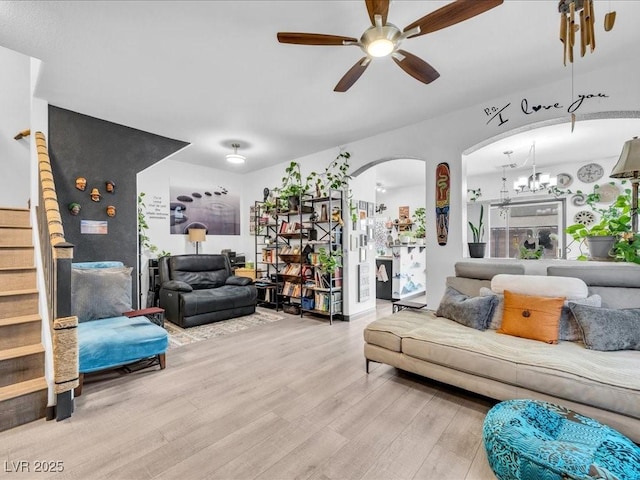 6324 Desert Leaf St Unit 3, North Las Vegas, NV 89081 - living area featuring wood finished floors, ceiling fan with notable chandelier, arched walkways, and stairs