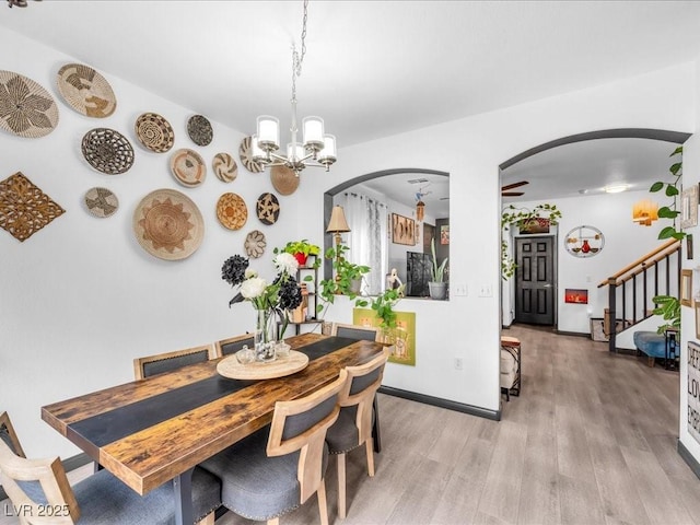 6324 Desert Leaf St Unit 3, North Las Vegas, NV 89081 - dining room with an inviting chandelier, wood finished floors, baseboards, arched walkways, and stairs