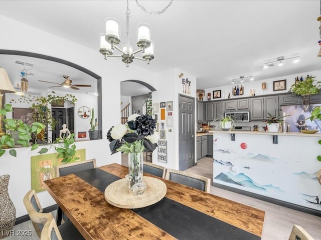 6324 Desert Leaf St Unit 3, North Las Vegas, NV 89081 - dining area featuring stairs, ceiling fan with notable chandelier, visible vents, light wood-style flooring, and arched walkways