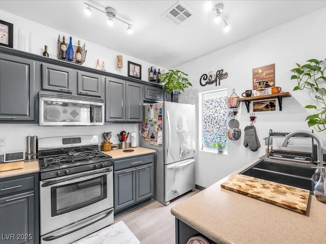 6324 Desert Leaf St Unit 3, North Las Vegas, NV 89081 - kitchen with light wood finished floors, a sink, stainless steel appliances, track lighting, and visible vents