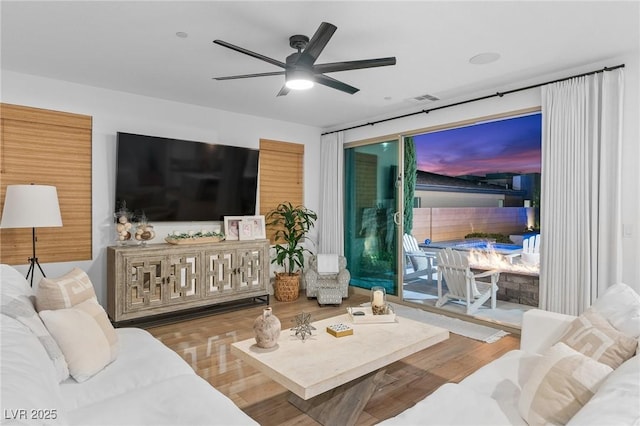 living room with visible vents, ceiling fan, and wood finished floors