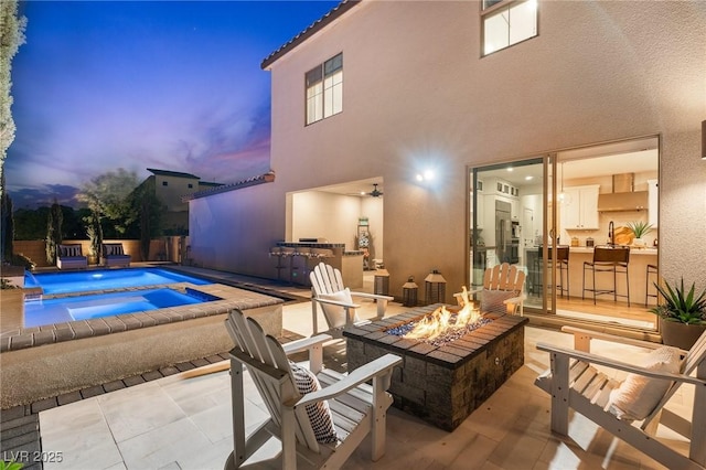view of swimming pool with a patio, a fire pit, a fenced in pool, and an in ground hot tub