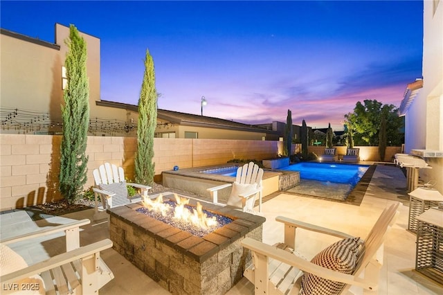 view of swimming pool featuring a fenced in pool, a fenced backyard, a fire pit, and a patio area
