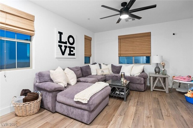 living room featuring visible vents, baseboards, ceiling fan, and wood finished floors