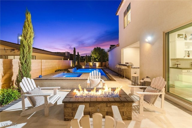 view of pool featuring a fire pit, a patio, a fenced backyard, a fenced in pool, and exterior kitchen