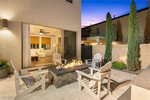 patio terrace at dusk with fence and an outdoor fire pit