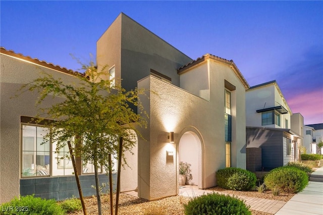 mediterranean / spanish house with stucco siding and a tiled roof