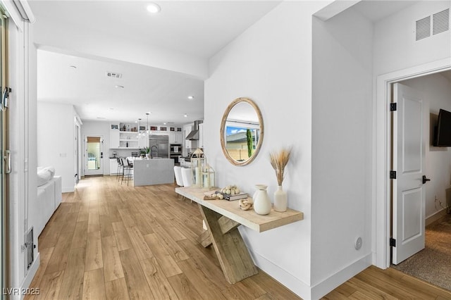 corridor featuring recessed lighting, visible vents, and light wood-style flooring