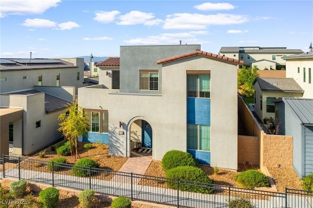 mediterranean / spanish-style house with a residential view, fence private yard, and stucco siding