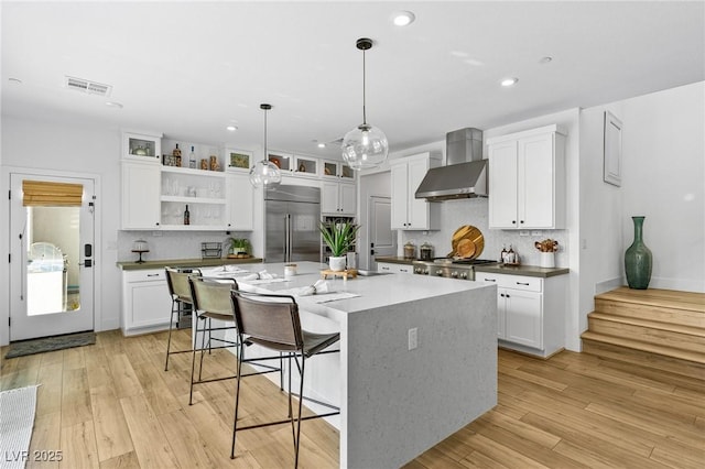 kitchen with white cabinets, open shelves, wall chimney exhaust hood, decorative backsplash, and stainless steel built in fridge