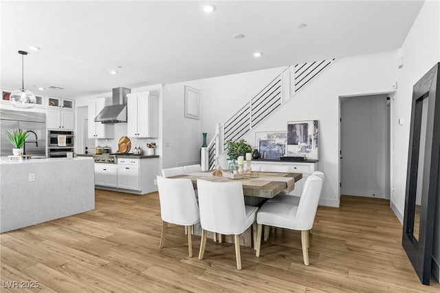 dining area with recessed lighting, stairs, and light wood finished floors