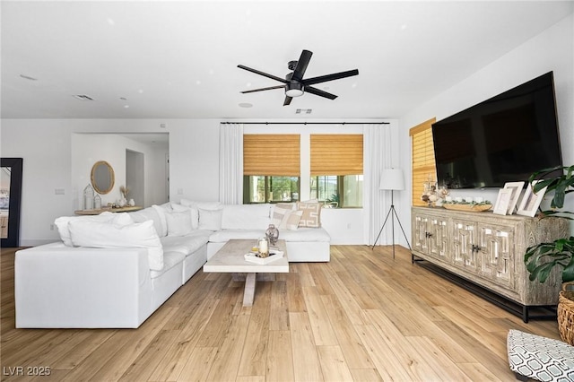 living area featuring a ceiling fan, wood finished floors, and visible vents