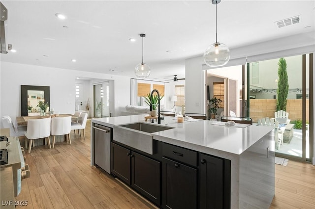kitchen featuring a sink, light countertops, open floor plan, stainless steel dishwasher, and visible vents