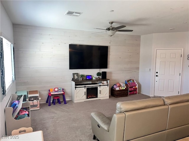 2585 Amazing Meadows Ave Unit 1007, North Las Vegas, NV 89031 - living area featuring ceiling fan, carpet flooring, wooden walls, and visible vents