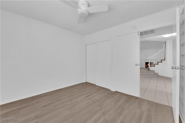 2808 Deep Water Cir, Las Vegas, NV 89117 - unfurnished room featuring ceiling fan, stairs, wood finished floors, and a textured ceiling