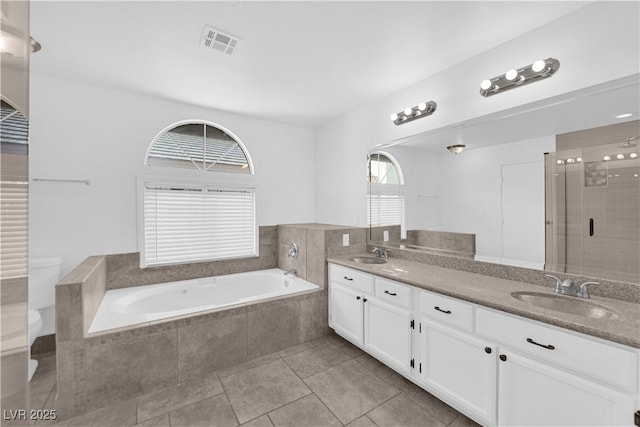 2808 Deep Water Cir, Las Vegas, NV 89117 - bathroom featuring toilet, double vanity, a garden tub, tile patterned flooring, and a stall shower