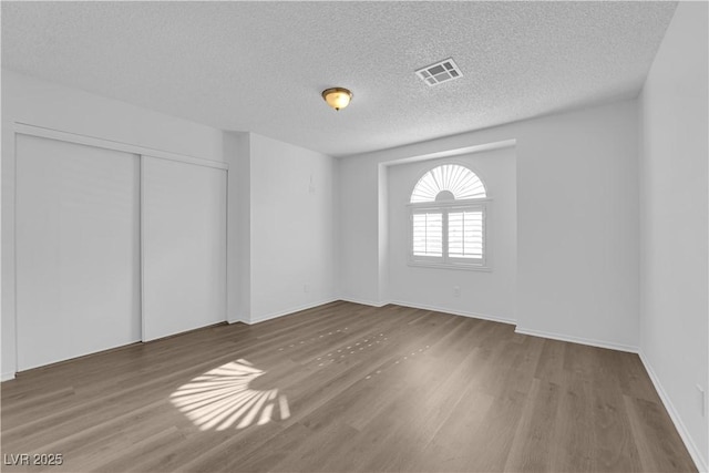 2808 Deep Water Cir, Las Vegas, NV 89117 - unfurnished bedroom with wood finished floors, a textured ceiling, a closet, and baseboards