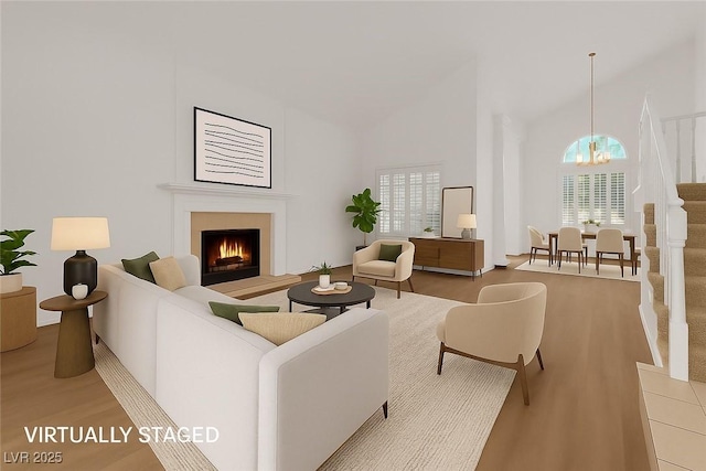 2808 Deep Water Cir, Las Vegas, NV 89117 - living room with a chandelier, high vaulted ceiling, wood finished floors, and a warm lit fireplace