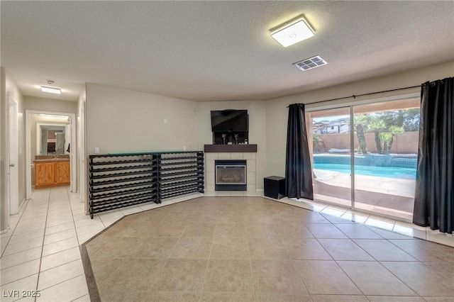 7751 Locke Haven Dr, Las Vegas, NV 89123 - unfurnished living room featuring light tile patterned floors, a textured ceiling, a fireplace, and baseboards