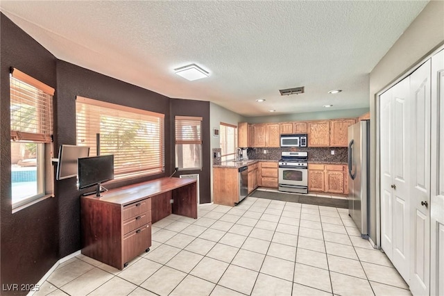 7751 Locke Haven Dr, Las Vegas, NV 89123 - kitchen featuring stainless steel appliances, healthy amount of natural light, decorative backsplash, a sink, and a textured ceiling