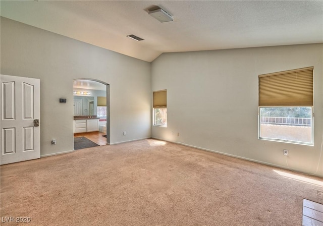 7751 Locke Haven Dr, Las Vegas, NV 89123 - unfurnished bedroom with carpet, multiple windows, arched walkways, high vaulted ceiling, and ensuite bathroom