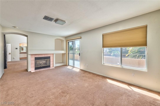 7751 Locke Haven Dr, Las Vegas, NV 89123 - unfurnished living room with carpet floors, a fireplace, arched walkways, a textured ceiling, and baseboards