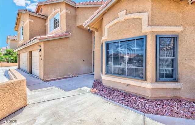 7751 Locke Haven Dr, Las Vegas, NV 89123 - doorway to property with stucco siding, a tile roof, an attached garage, and driveway