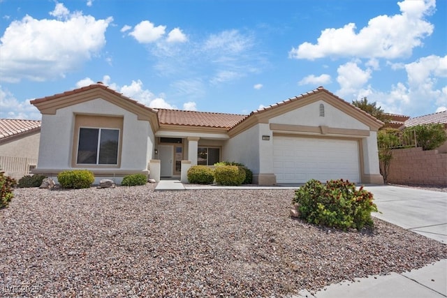 view of front of property with fence, an attached garage, driveway, and stucco siding