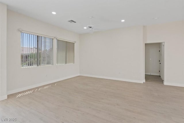 empty room featuring baseboards, ceiling fan, light wood-type flooring, and visible vents