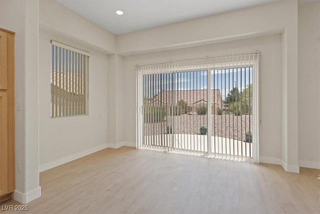 spare room with baseboards, recessed lighting, and wood finished floors