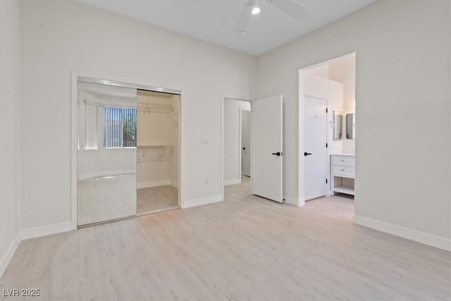 unfurnished bedroom featuring connected bathroom, a ceiling fan, baseboards, and wood finished floors
