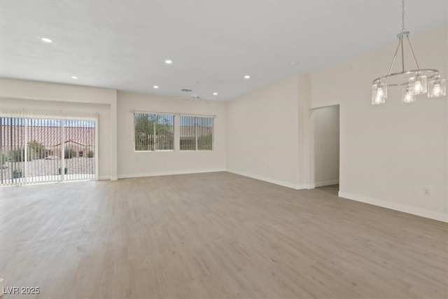 unfurnished living room featuring an inviting chandelier, baseboards, recessed lighting, and light wood-style flooring