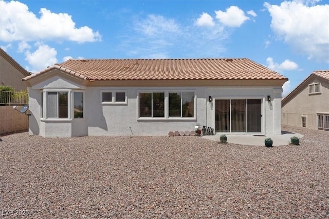 rear view of property with fence, a patio, stucco siding, and a tile roof