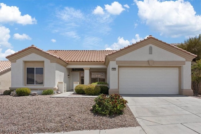 mediterranean / spanish-style house with a garage, driveway, a tile roof, and stucco siding
