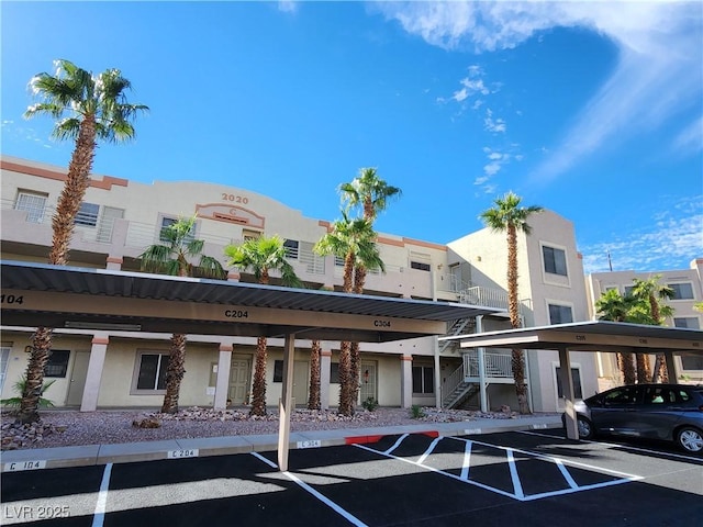 view of property with covered parking and stairway