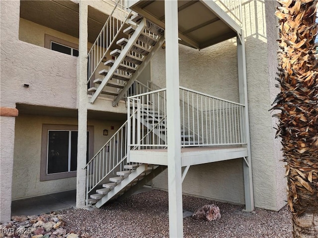 view of property exterior featuring stucco siding and stairway