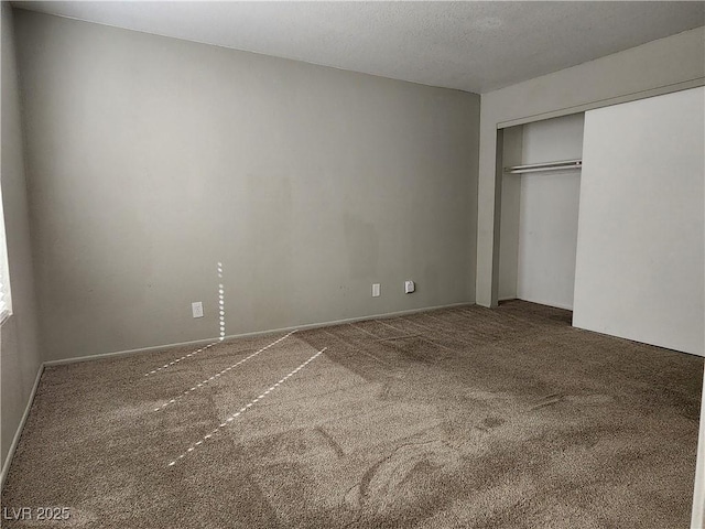 unfurnished bedroom featuring carpet floors, a closet, and a textured ceiling