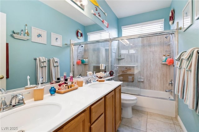 full bathroom with toilet, tile patterned floors, double vanity, and a sink